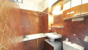 A bathroom with a white sink, a toilet, and a mirror above the sink.