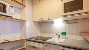 A compact kitchen with white cabinets, a microwave, a stove, and a dishwasher. - **Cozy Ski-In/Ski-Out Apartment Near Children's Village, Sleeps 5** (Val-d'Isère)
