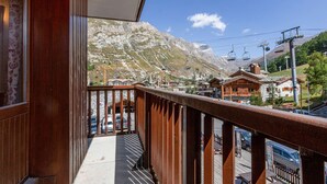 A wooden balcony with a view of a mountain and a ski lift. - **Cozy Ski-In/Ski-Out Apartment Near Children's Village, Sleeps 5** (Val-d'Isère)