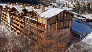 A wooden lodge with multiple balconies and a ski slope in the background. - Elegant apartment in Val-d'Isère with balcony, parking, wifi (Val-d'Isère)