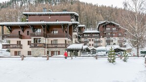 Ein mehrstöckiges Hotel mit Balkonen und Blick auf ein Skigebiet.