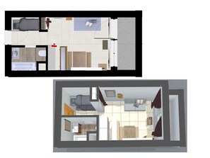 Blick von oben auf ein Hotelzimmer mit Bett, Schreibtisch, Stuhl, Badezimmer und einem kleinen Balkon.