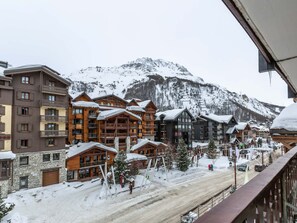 A snow-covered mountain town with wooden buildings and a ski slope.
