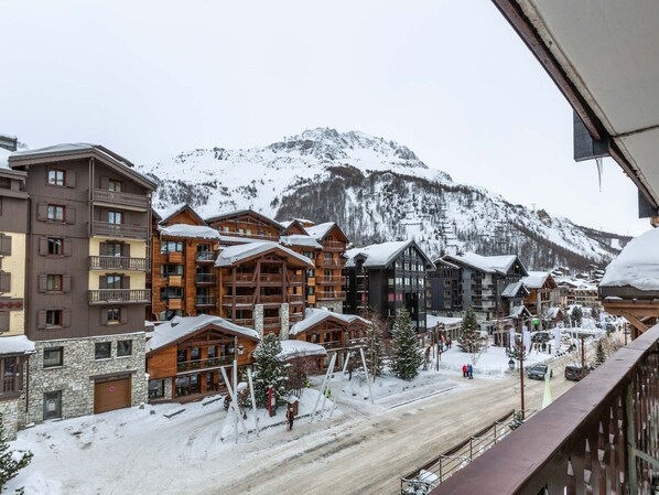 A snow-covered mountain town with wooden buildings and a ski slope.