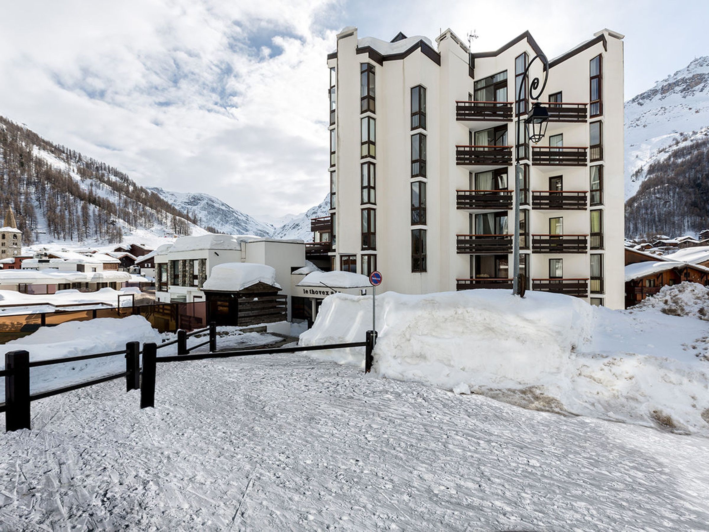 Un hotel de varios pisos con balcones y un paisaje nevado.