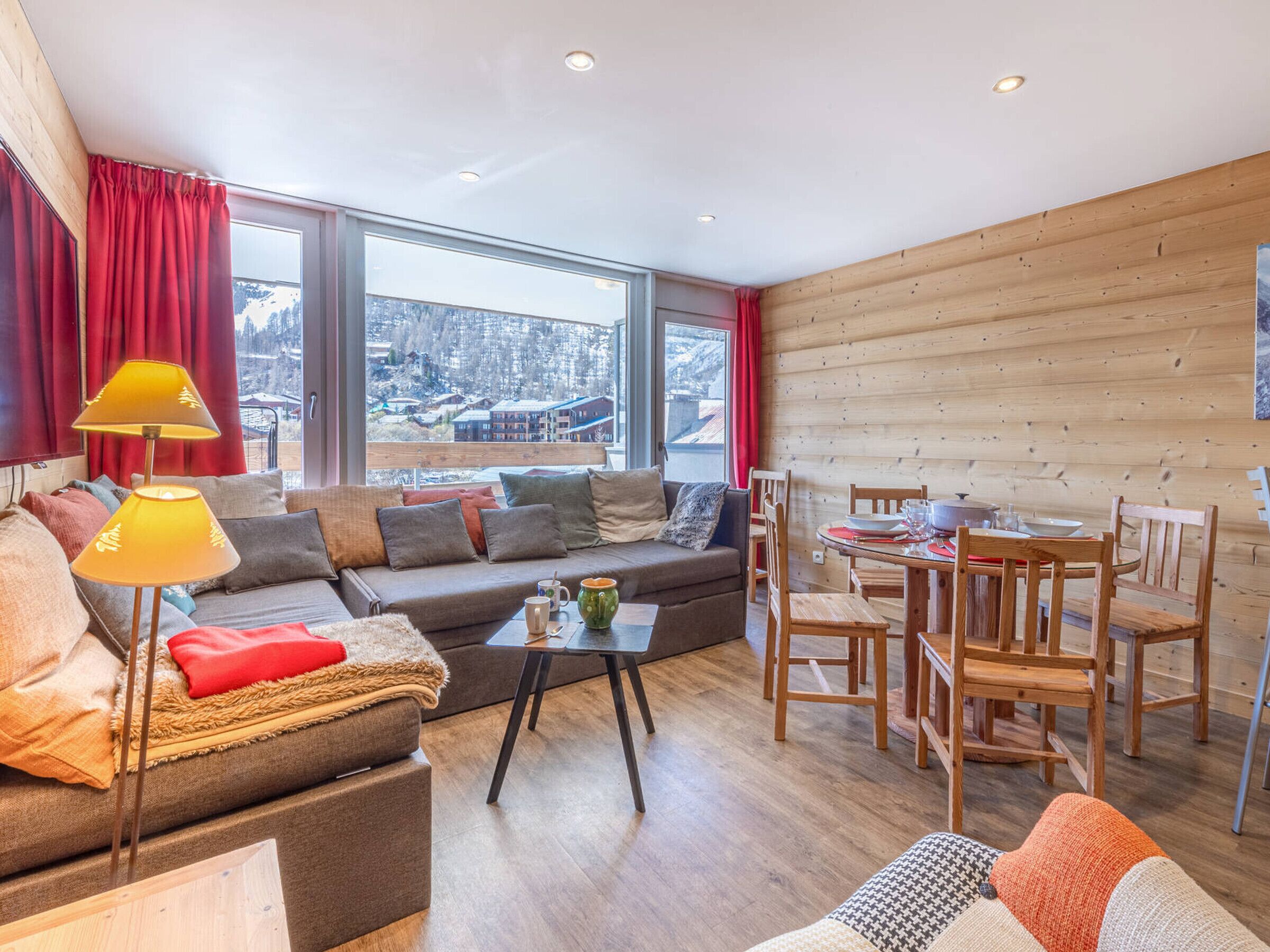 A cozy living room with a sofa, coffee table, and dining area.