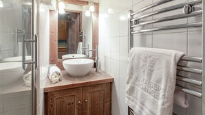 Une salle de bain moderne avec un meuble-lavabo en bois, un grand miroir et un porte-serviettes.
