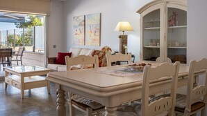 A spacious living room with a dining area, large windows, and a view of the outdoors. - Seaside apartment with terrace and communal pool (Torredembarra)