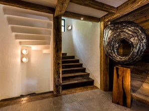 A staircase with wooden steps and a textured wall sculpture. - Luxurious Chalet with Pool, Hammam & Stunning Views in Val-d'Isère (Val-d'Isère)
