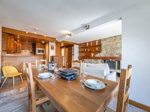 Comedor con mesa de madera, sillas y una barra de desayuno.