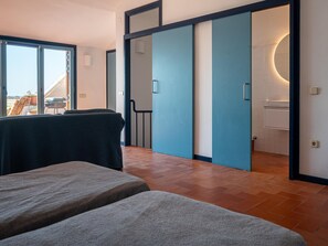 Un intérieur moderne avec un canapé, une porte coulissante et une vue sur l’extérieur.