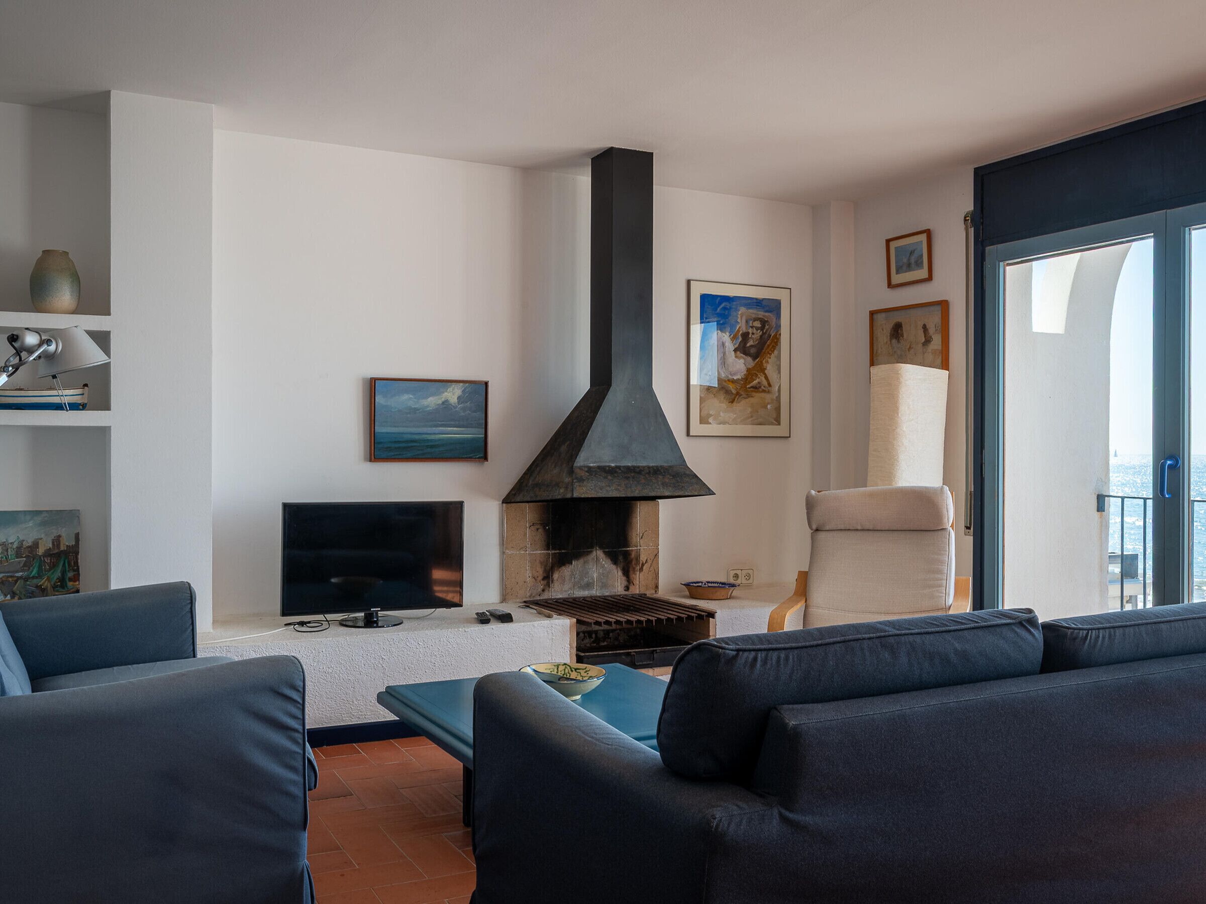 A living room with a fireplace, a television, and a sofa.
