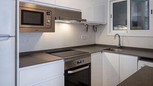A modern kitchen with white cabinetry, a stainless steel microwave, a built-in oven, and a Siemens dishwasher. - Bright apartment sea view - 4 guests (Torredembarra)