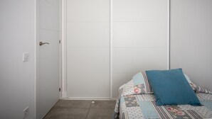 A bedroom with a bed, a sliding door, and a wall socket. - Bright apartment sea view - 4 guests (Torredembarra)