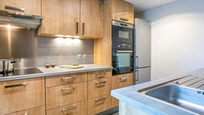 Eine moderne Küche mit Holzausstattung, Edelstahlgeräten und einer integrierten Spüle.