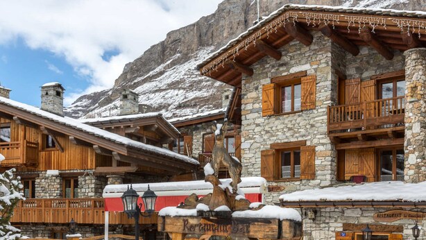 Ein rustikales Berglodge mit Stein- und Holzarchitektur, inklusive Restaurant und Bar.
