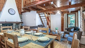 Ein gemütliches Blockhaus mit Essbereich, Kamin und Schlafgalerie.