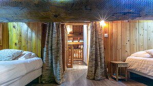 Ein gemütliches Zimmer mit zwei Betten, Holzwänden und einer Holzboden.