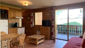 A cozy room with wooden furniture, a kitchen area, and a balcony with a view. - 28m² Mountain studio for 4 with balcony in Pra-Loup (Pra-Loup)