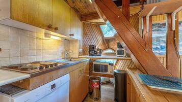 A compact kitchen with wooden cabinets, a Bosch dishwasher, a sink, a microwave, and a coffee maker.
