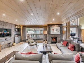 A spacious living room with a fireplace, a flat-screen TV, and a balcony with outdoor seating. - Luxury Duplex Apartment in Central Val-d'Isère, Near Slopes, with Large South-Facing Terrace (Val-d'Isère)