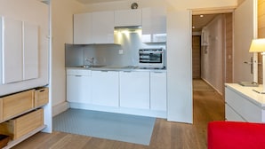 A compact kitchen with white cabinets, a built-in oven, and a sink. - Modern Studio with Balcony, Ski-In/Ski-Out, and Free WiFi in Val-d'Isère (Val-d'Isère)