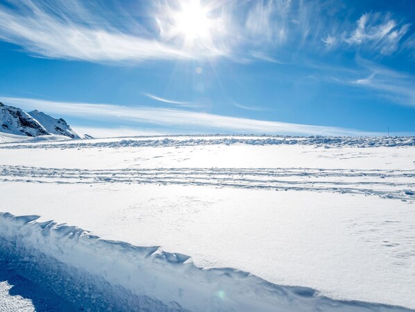 A snowy landscape with a clear sky and distant mountains.
