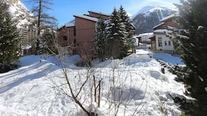 Un villaggio montano innevato con edifici e alberi.