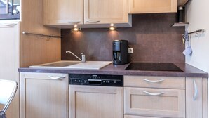 Una cucina moderna con mobili in legno, lavastoviglie integrata e macchina per il caffè.
