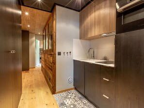 Eine moderne Küche mit Holzschränken, einer Edelstahlspüle und einem eingebauten Backofen.