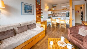 Un salon chaleureux avec un canapé, une table basse et un coin repas comprenant une table et des chaises.