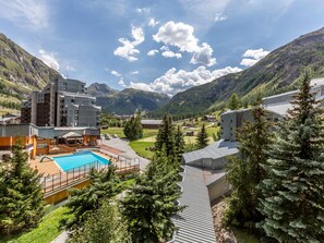 A hotel with a pool, surrounded by mountains and trees. - Comfortable ski-in/ski-out apartment in La Daille, pets allowed (Val-d'Isère)