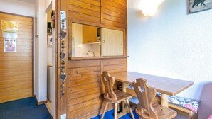 Un interior de fusta amb taula i cadires, un mirall i un llum penjant a la paret.