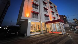 A multi-story hotel with illuminated balconies and a ground-level entrance with a red awning. - MY PALACE TUZLA (Tuzla)