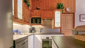Eine moderne Küche mit Holzschränken, Edelstahlgeräten und einer großen Kochinsel.