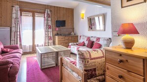 Ein gemütliches Wohnzimmer mit Holzwänden, einer Couch, einem Holztisch und einer Lampe.
