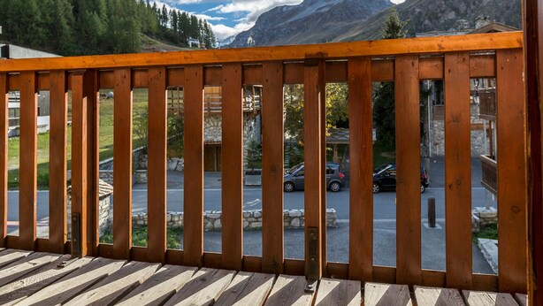 Eine Holzterrasse mit Blick auf einen Berg und einen Parkplatz.