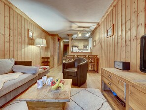 A cozy cabin interior with a sofa, coffee table, and dining area.