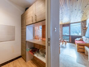 A modern interior with wooden cabinetry, a dining area with a view, and a cozy seating area.