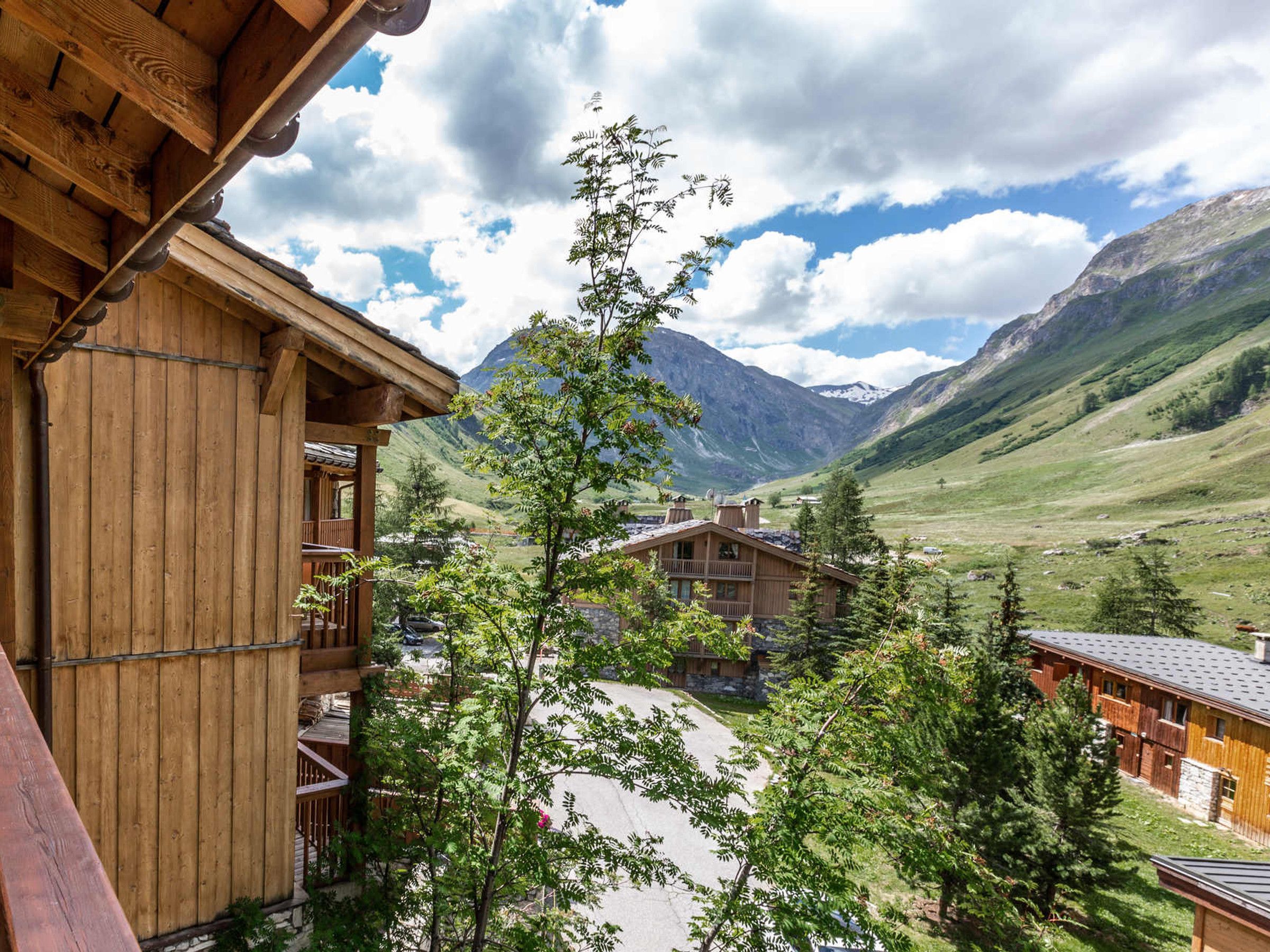 A wooden building with balconies overlooking a mountainous landscape.