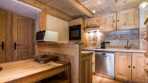 Eine Holzküche mit Mikrowelle, Backofen, Kaffeemaschine und Geschirrspüler.