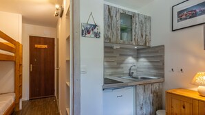 A compact kitchen with a built-in sink, wooden cabinets, and a small countertop.