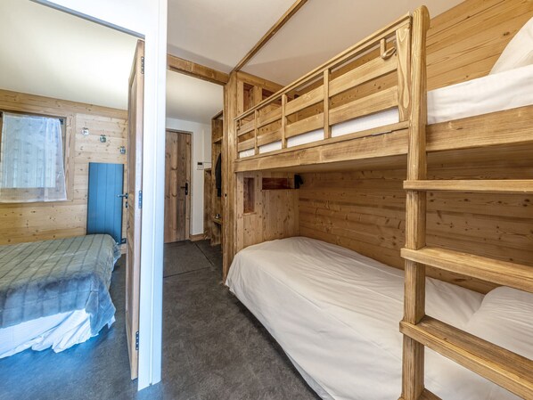 Dormitorio con literas, paredes de madera y ventana.