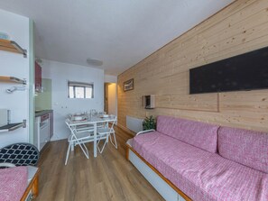 Ein kompakter Wohnbereich mit Küchenzeile, Essplatz und einer Couch.