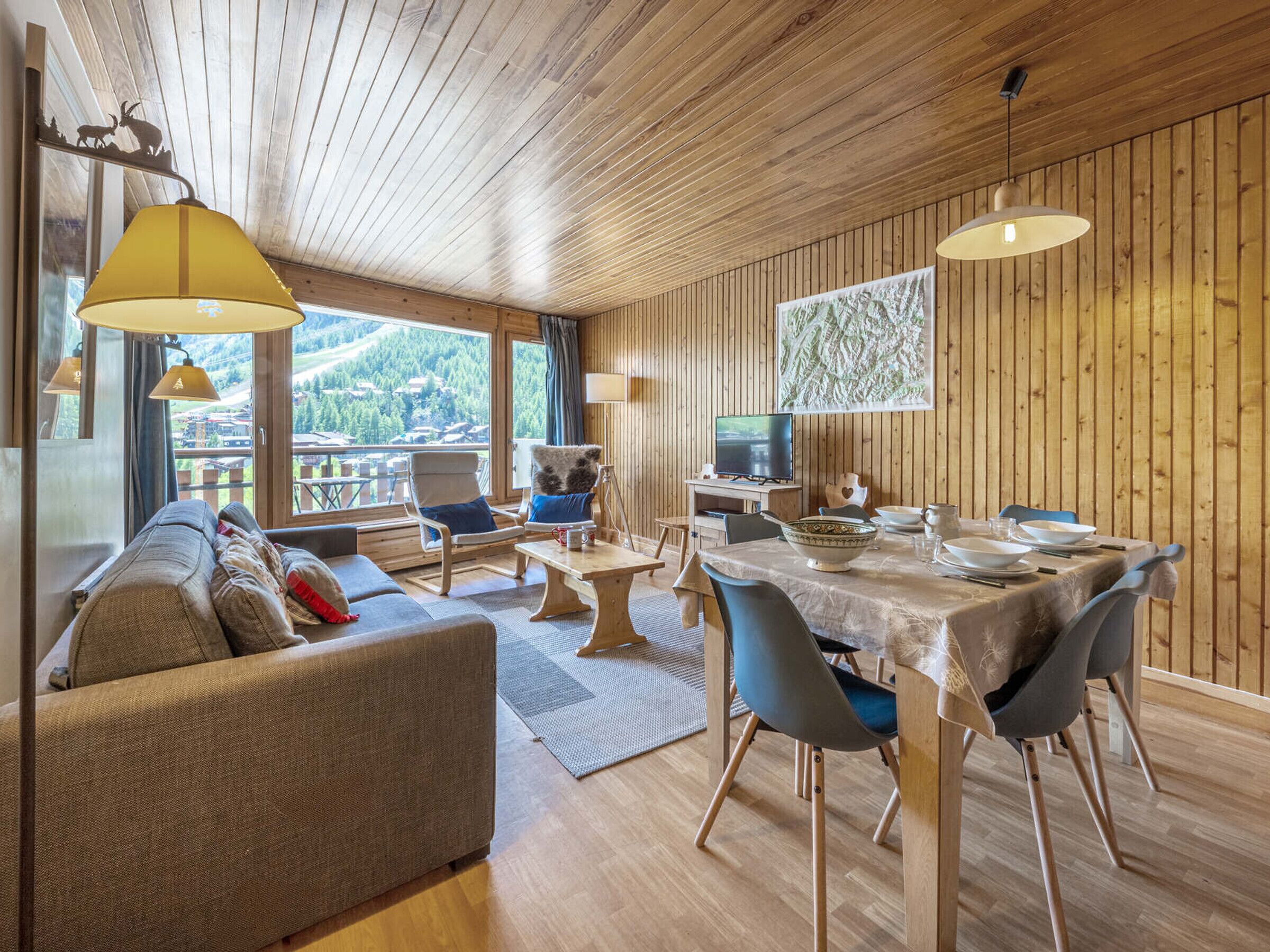 Une pièce confortable avec un canapé, une table à manger, des chaises et un téléviseur.