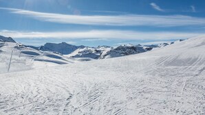 Un paysage de montagne enneigé, avec un ciel dégagé.