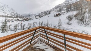 Un paysage montagneux enneigé, avec une station de ski en arrière-plan.