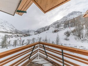 A snow-covered mountain landscape with a ski resort in the background.