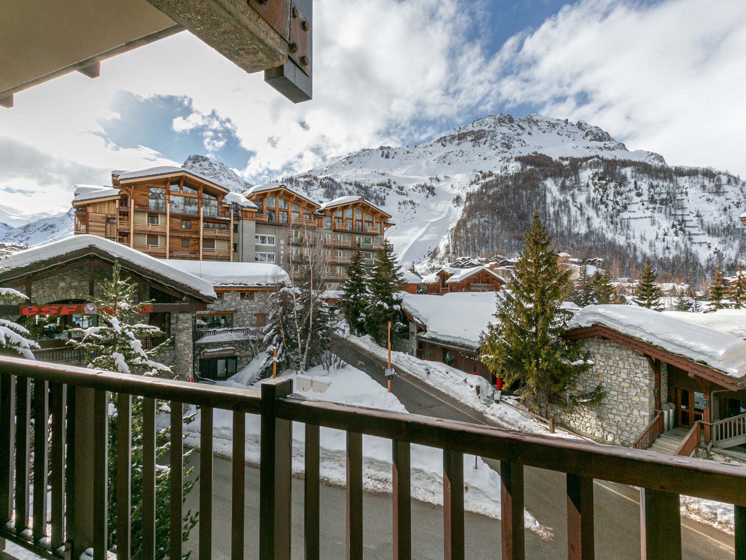 A snow-covered mountain town with wooden buildings and a ski slope.