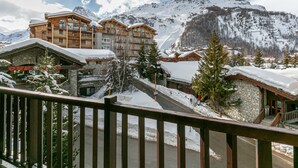 Une ville de montagne enneigée, avec des bâtiments en bois et une piste de ski.